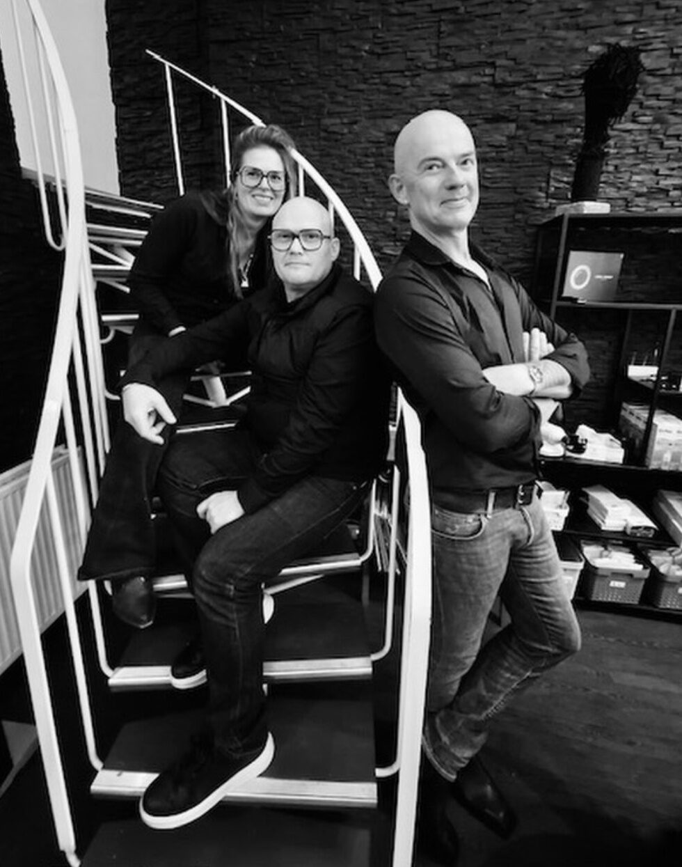 Het team van Blincq Optiek op de trap in de winkel